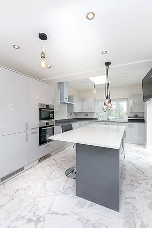 Kitchen interior with white marble floors and white countertops and cupboards