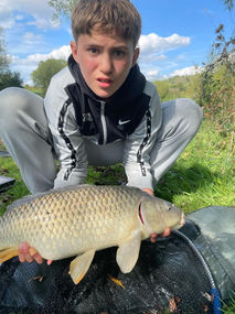 Young boy holding up a fish after catching it in a net