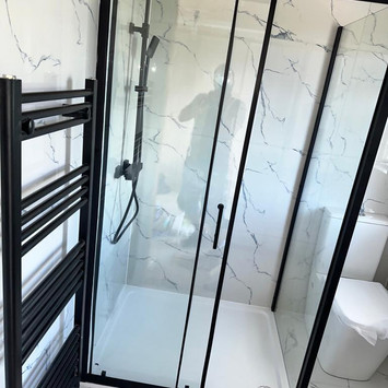 Bathroom interior with black shower and white tiled walls