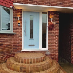 Blue door on red brick house with brick steps