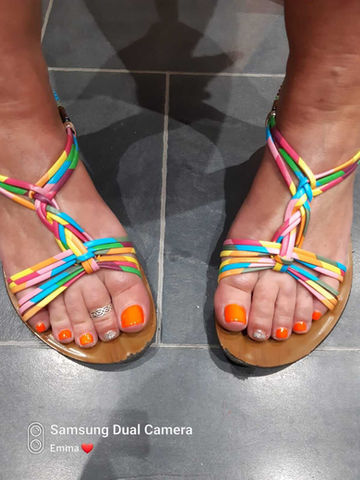 Woman's feet with orange gel polish 