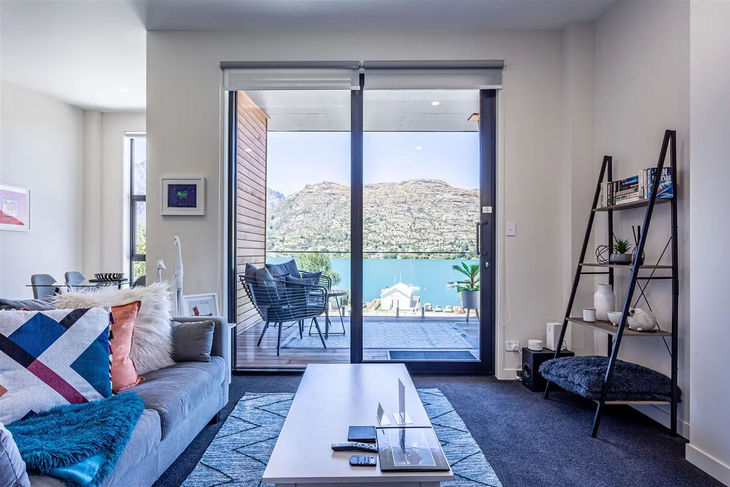 a living room with a view of a lake and mountains