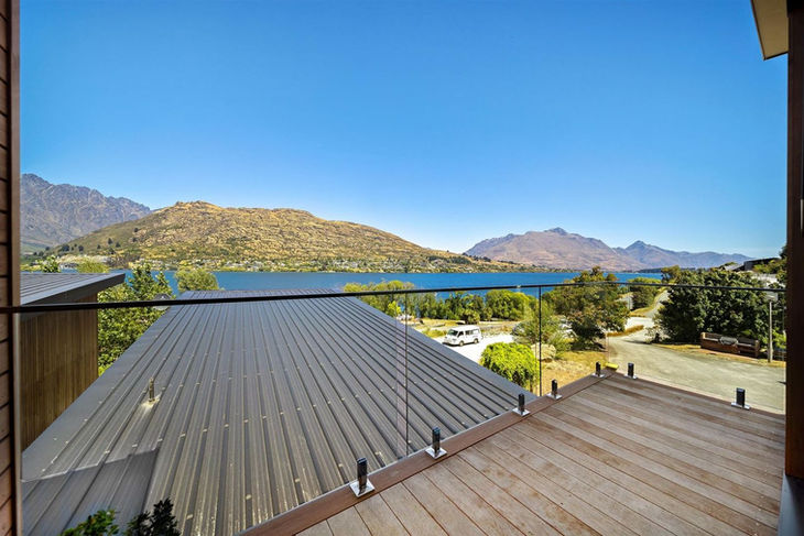 a balcony overlooking a lake with mountains in the background