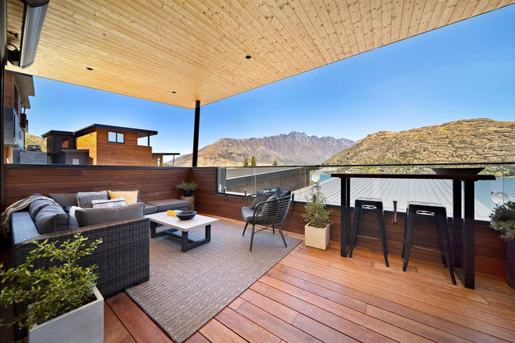 a balcony with a view of mountains and a table and chairs
