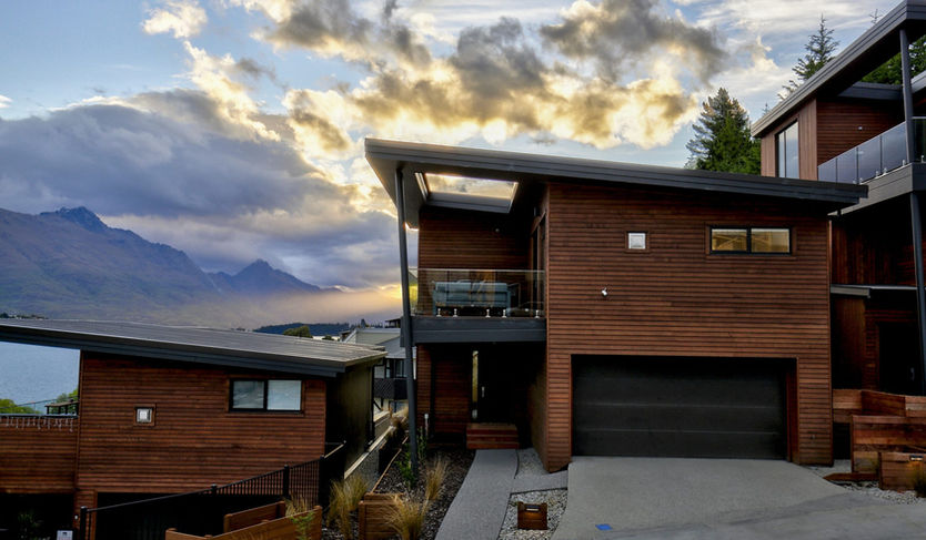 a house with a balcony and mountains in the background