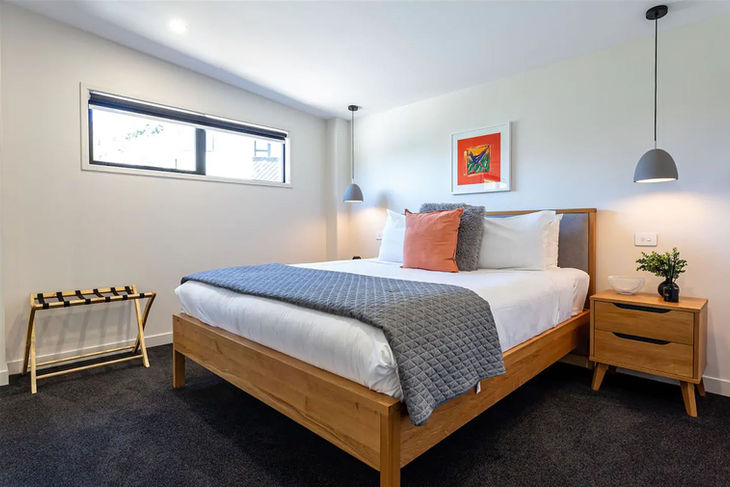 a bedroom with a bed and a picture on the wall