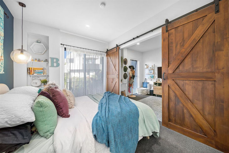 a bedroom with sliding barn doors and the letter b on the wall