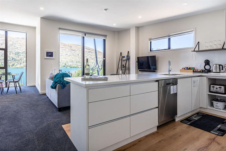 a kitchen with white cabinets and a stainless steel dishwasher