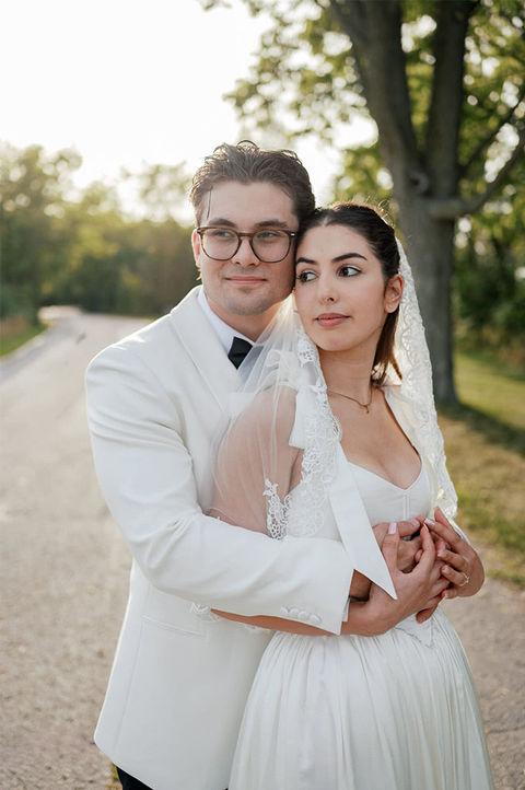 Beautiful couple embracing. He has his arms around her waist and she is holding his hands
