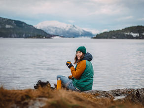 Abigail drinkt een kop thee met uitzicht over de Noorse fjorden.