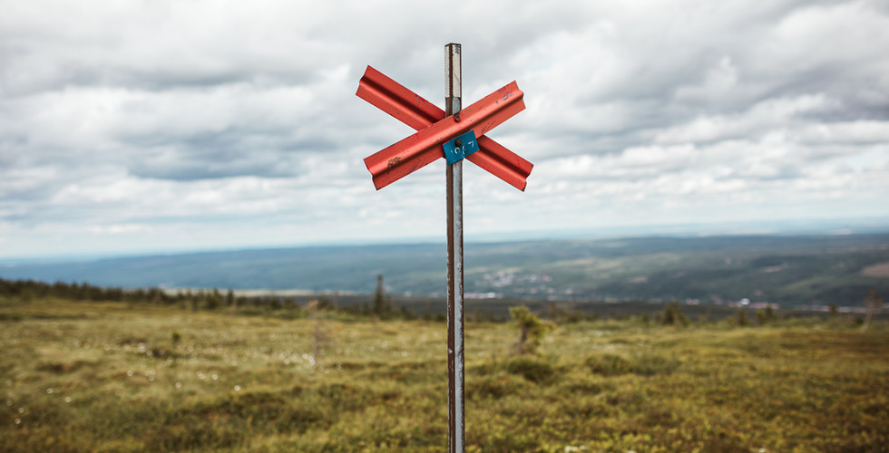 Rood kruis langs een hiking trail in Zweden, passend bij een blog over inzicht en keuzes maken in je fotografiebedrijf