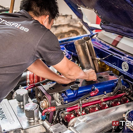 A Tensai Professional working on a car engine