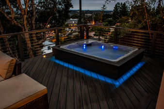 Jacuzzi Spa built into deck halfway underground with outdoor lighting and stainless cable handrailing