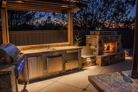 Complete outdoor kitchen built with Stainless appliances, BBQ Grill, Sink, Fridge, Stone Outdoor Fireplace