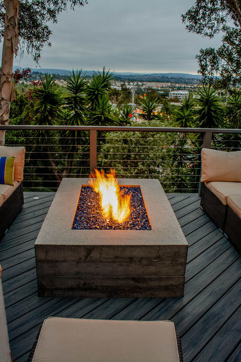 modern outdoor living space design with custom concrete gas fire pit, cable rail, composite Trex deck and seating area
