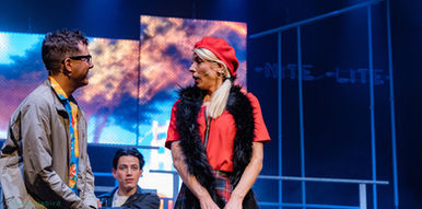 Three ZEST actors on stage for Dogfight the musical, November 2024, with a lively, abstract backdrop.