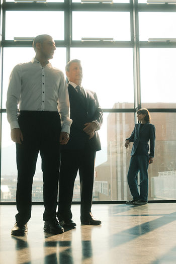 Three actors in a high-rise office for ZEST’s Farragut North, June 2026. Dramatic lighting and city views.