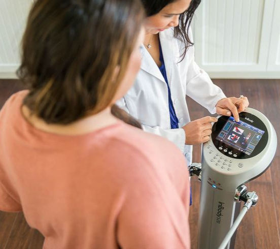 Doctor using InBody machine to perform body fat analysis on patient at Nova Aesthetic Clinic.