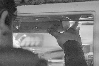 Certified technician diagnosing fridge on a service call.