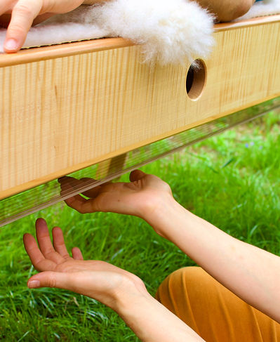 Klangliege aus Holz mit bespannten Saiten am unteren Korpus. Entspannung, Regeneration, Nervensystemregulation