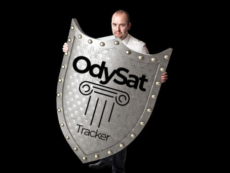 Hombre sosteniendo un escudo metálico con el logo de OdySat Tracker, símbolo de protección y confianza frente a rastreadores obsoletos.