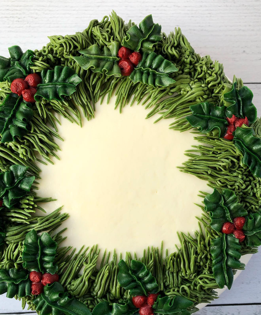 Buttercream piping into a wreath and holly berries