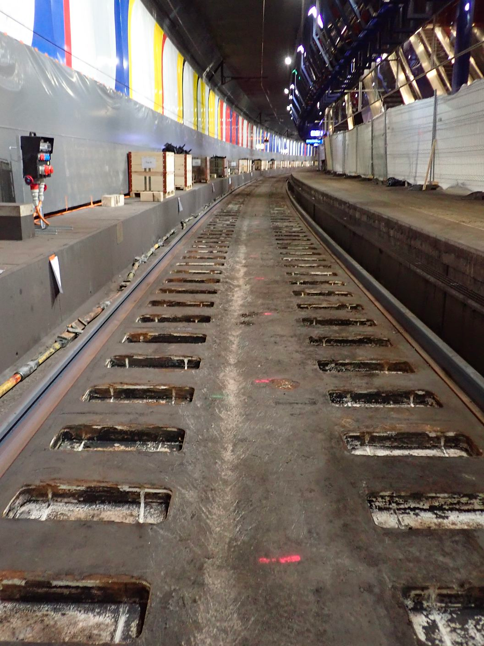 Gleisbereich im Bahnhof Zürich Flughafen mit entfernten Schienen und Schwellen. In der Betonplatte sind die Auslassungen für die Schwellen zu erkennen.