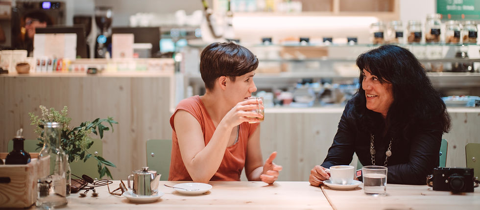 Two women sharing their experiences over coffee.