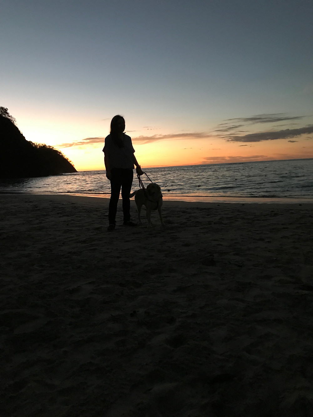 PD: A picture of Kristin and Zoe standing on the beach, looking towards the ocean, as the sunsets in a beautiful sky. Costa Rica 2018.