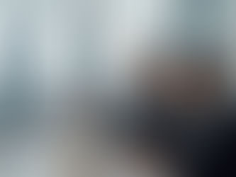 Two professionals in suits discuss data on a futuristic screen in a modern office with city skyline views, exuding a focused atmosphere.