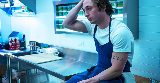 Carmine "Carmy" Berzatto, protagonista di The Bear, seduto sulla cucina con la mano nei capelli