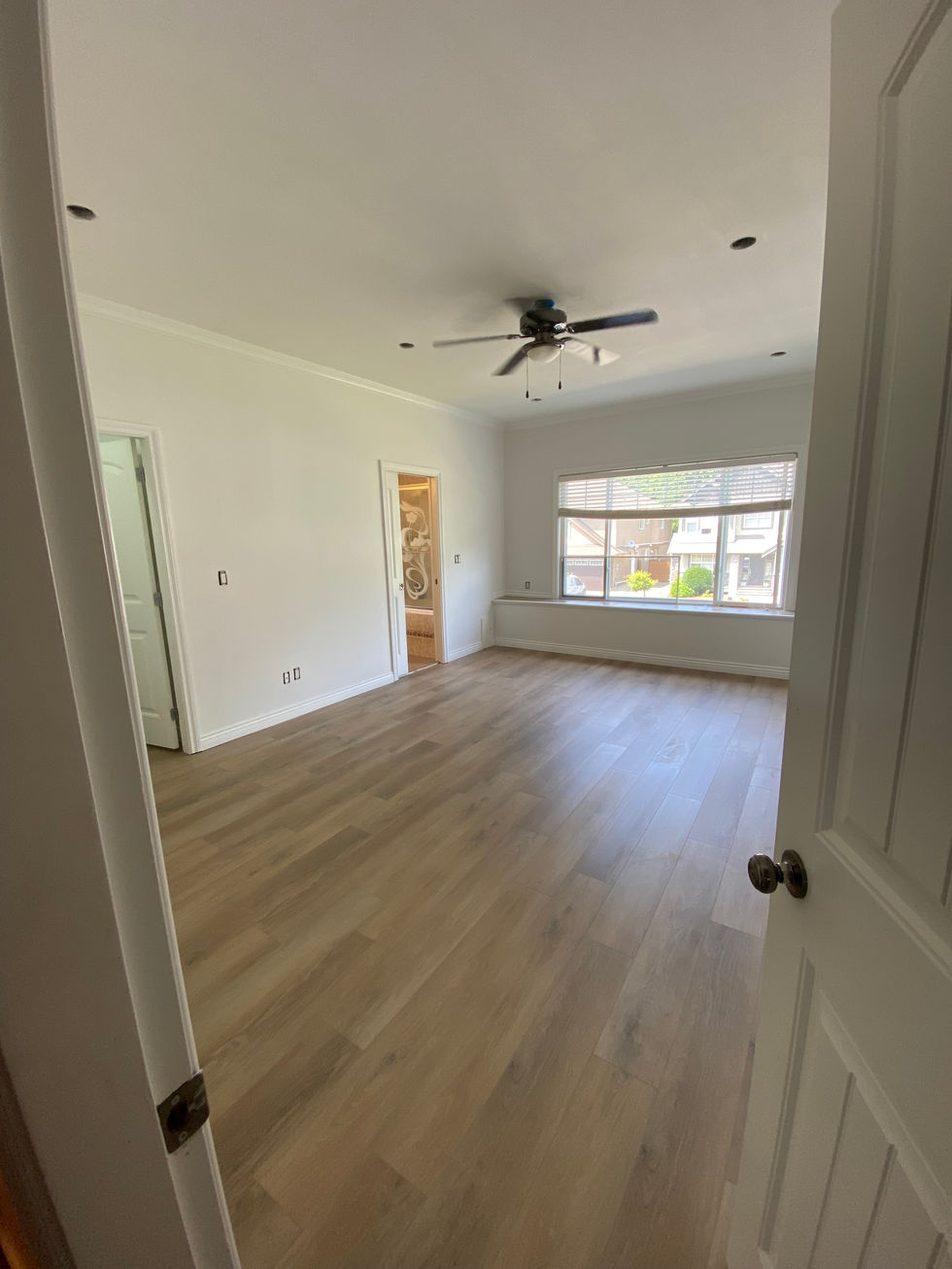 Spacious room with wood-look flooring and large window