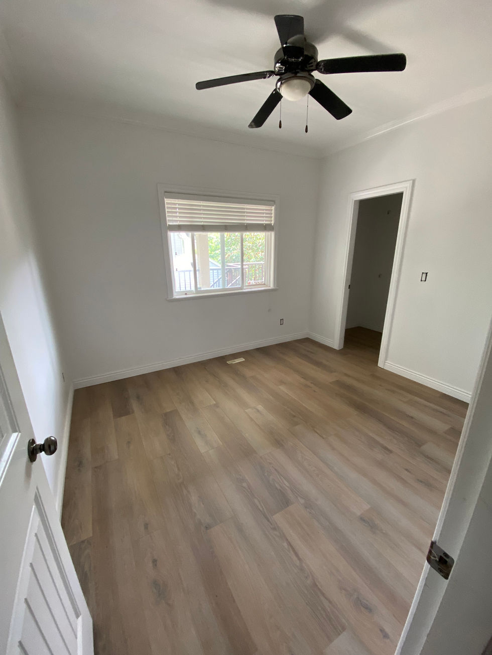 Spacious bedroom with wood-look floors