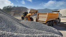 Front loader pours gravel into dump truck in a quarry