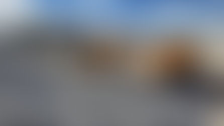 Front loader pours gravel into dump truck in a quarry