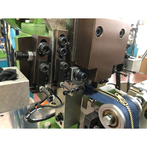 a zipper machine working on a blue metal zipper