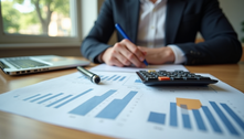 A professional carefully plans their emergency fund, using charts and a calculator to ensure a secure future.