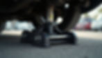Close-up view of a hydraulic jack lifting a car
