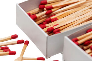 Open matchbox with red-tipped matches spilling out