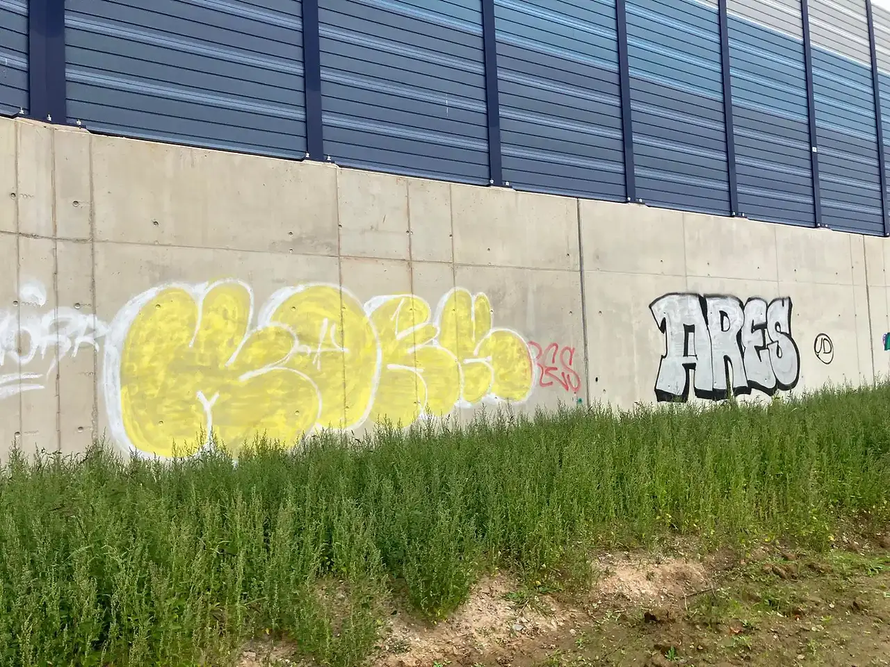 Graffitientfernung Düsseldorf: Betonwand mit mehrfarbigem Bubble-Tag und Schriftzug „ARES” vor der Reinigung