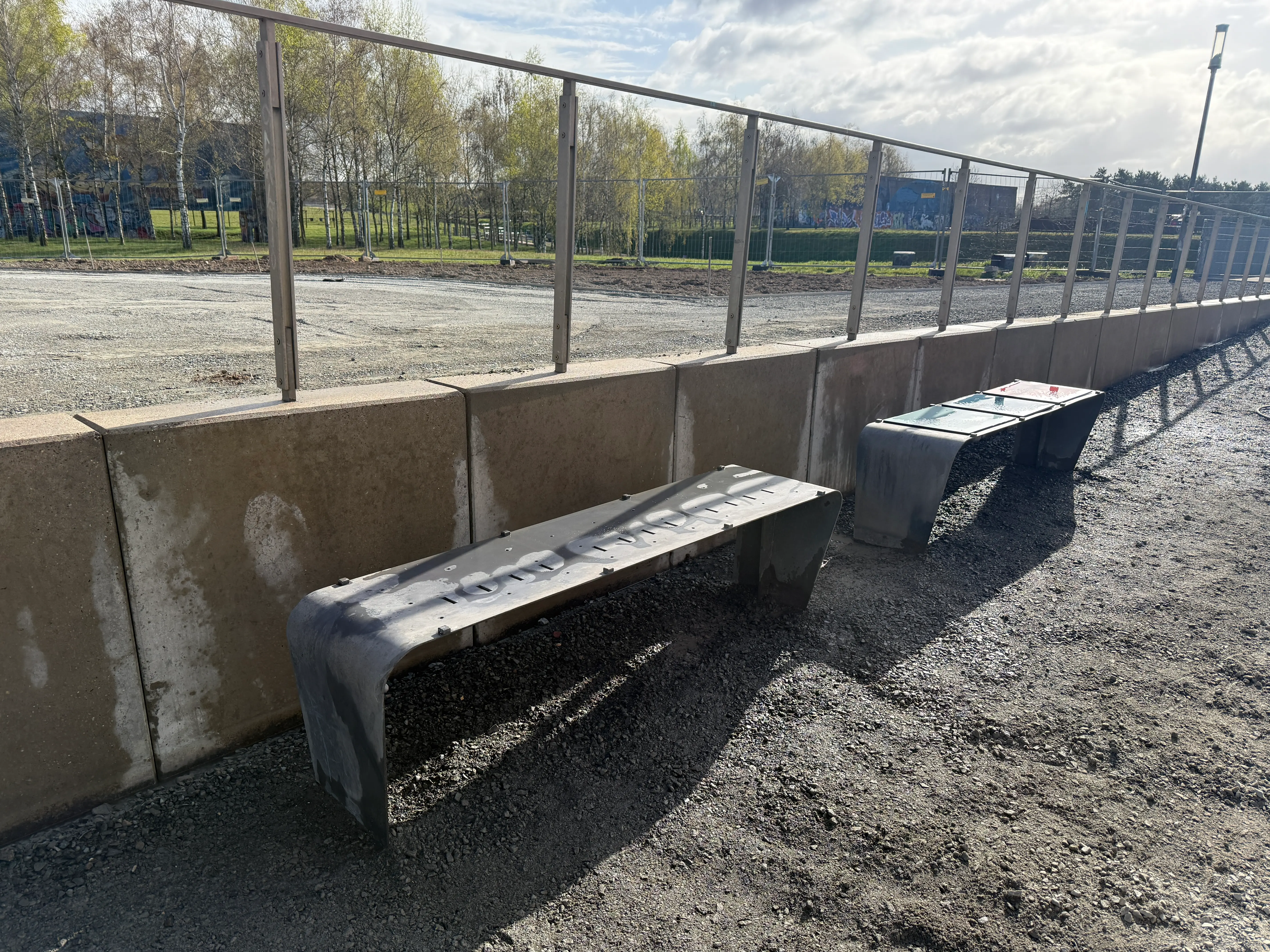 Graffitientfernung Zukunftsgarten Duisburg: gereinigte Bänke entlang der Betonmauer im Park