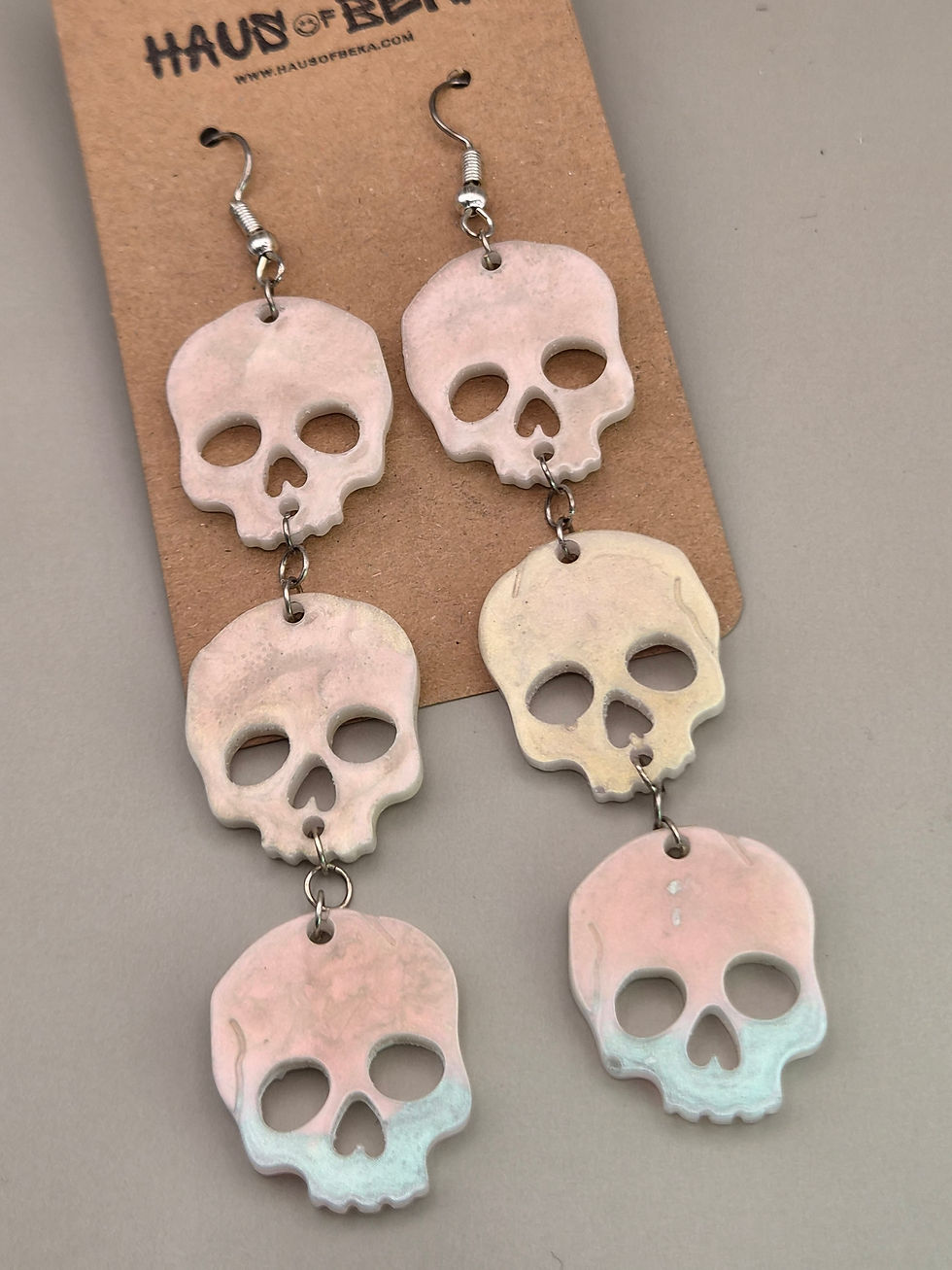 Thumbnail: Triple Skull Earrings – White Iridescent Resin Jewellery with Pink Shimmer