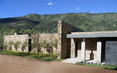 North Star Residence front elevation showcasing contemporary Aspen mountain architecture with natural stone cladding, clean modern forms, and panoramic views of the Rocky Mountains, designed by Z Group Architecture & Interior Design.