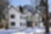 Winter view of a fully renovated Aspen home with white siding, black trim, and gabled roof in the historic Hallam neighborhood