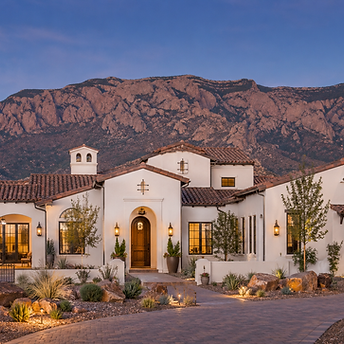 Custom home build Spanish-style house with white stucco, red spanish tile roof at . Desert xeriscape landscaping yard, albuquerque's sandia mountains in the background. new construction single family home in foothills new mexico