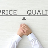 A person's hands resting below a drawn balance scale showing the words Price and Quality perfectly balanced on a white background, representing the relationship between cost and value.