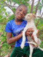 Young girl holding her tan and white dog in Liberia.