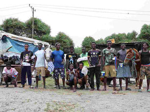 A group of young men with two horses stand in a row at a farrier station in Ghana.