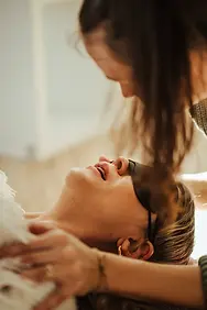 Begleiterin beugt sich einfühlsam über Teilnehmerin in Deep Trance Breathing Session mit Trance atmen in Graz