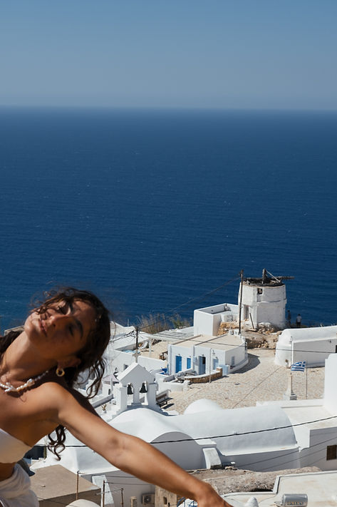 girl over the white village of anafi island, greece